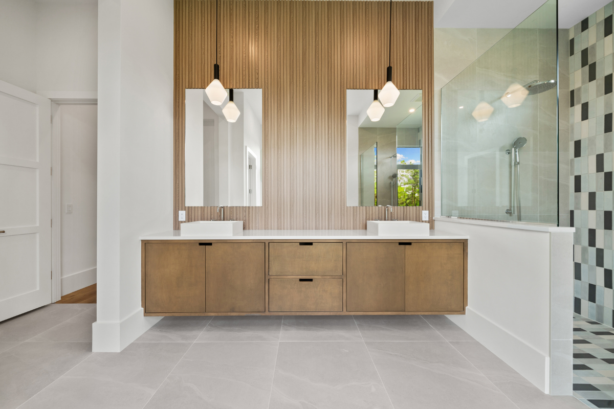 Modern floating wood bathroom vanity with dual sinks and vertical slat wall paneling.